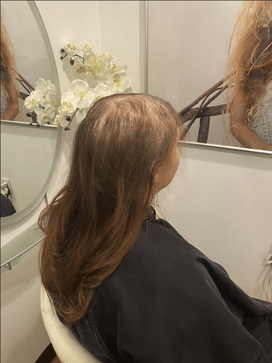 a woman standing in front of a mirror posing for the camera